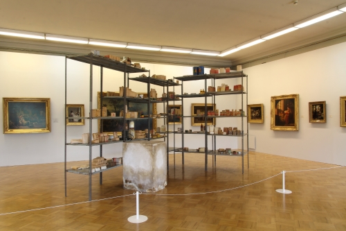 Joseph Beuys. Wirtschaftswerte (Economic Values), 1980. Iron shelves with basic food and tools from East Germany; plaster block with pencil and fat; paintings from the collection of the host museum. Shelves: 290 × 400 × 265 cm; Plaster block: 98.5 × 55.5 × 77.5 cm. Collection of S.M.A.K. Stedelijk Museum voor Actuele Kunst, Ghent, Belgium. Installation view, MANIFESTA 10, Winter Palace, State Hermitage Museum.